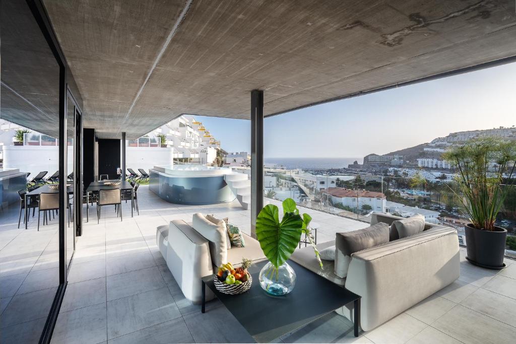 una sala de estar con un sofá y una mesa en The One Luxury Apartments, en Puerto Rico de Gran Canaria