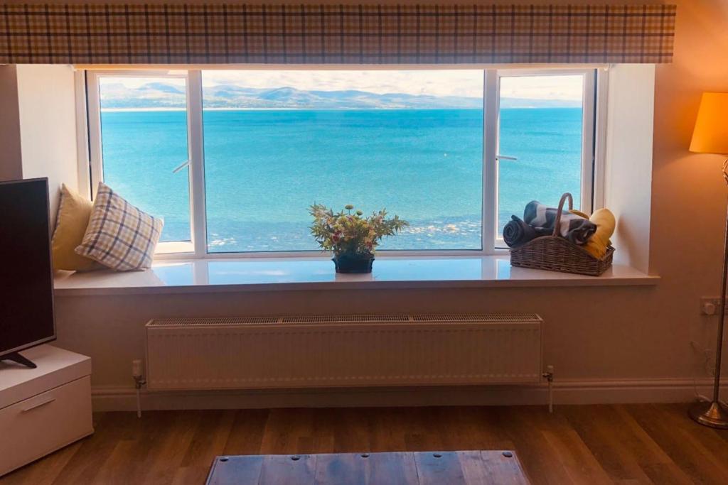a large window with a view of the ocean at The Iris in Criccieth