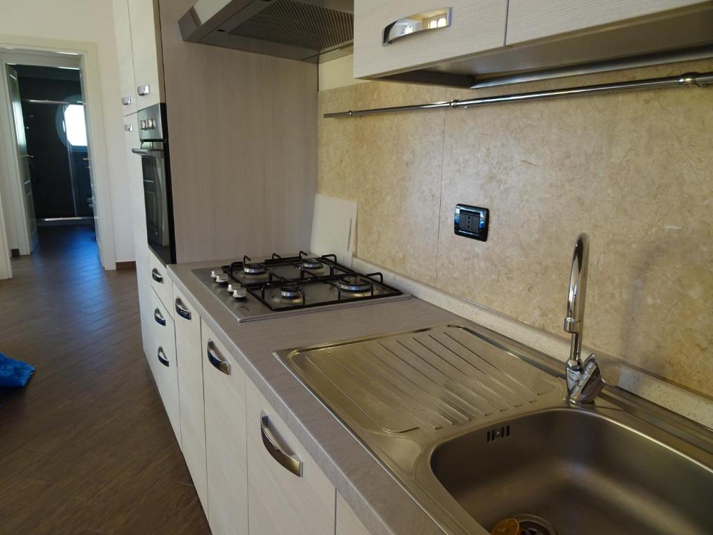 uma cozinha com um lavatório e um fogão em Casa Costa Outlet 5 em Serravalle Scrivia