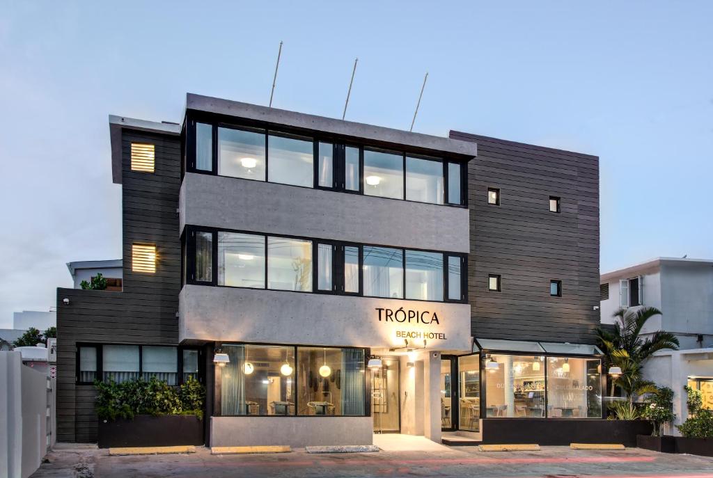 un grand bâtiment noir avec une façade de magasin dans l'établissement Trópica Beach Hotel, à San Juan