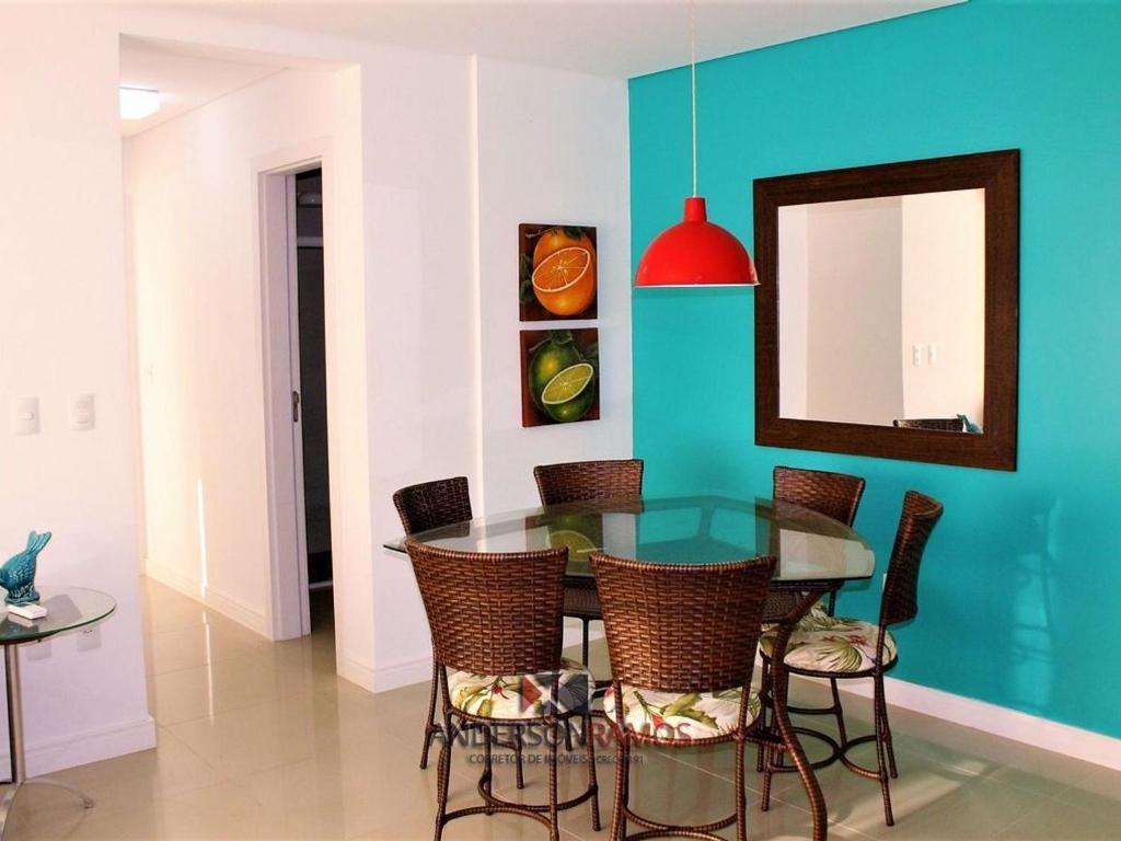 une salle à manger avec une table et des chaises en verre dans l'établissement 1007 Residencial Fontini Apto 302 - Praia de Bombas, à Bombinhas