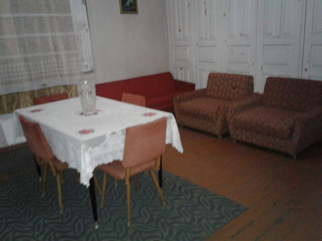 Levani's GuestHouse في زوغديدي: غرفة معيشة مع طاولة وكراسي وأريكة
