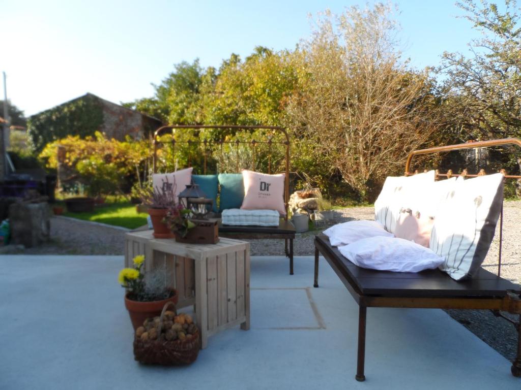 a patio with two beds and potted plants at Les chambres du Couraud in Saint-Aubin-des-Ormeaux