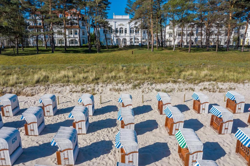- une plage de sable avec des chaises en face d'un bâtiment dans l'établissement Villa Salve, à Binz
