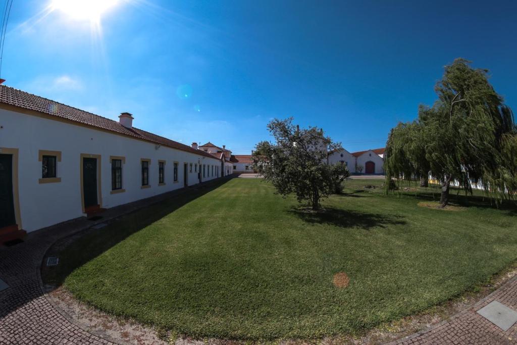 un bâtiment avec une cour herbeuse à côté d'un bâtiment dans l'établissement Casas do Monte, à Palmela