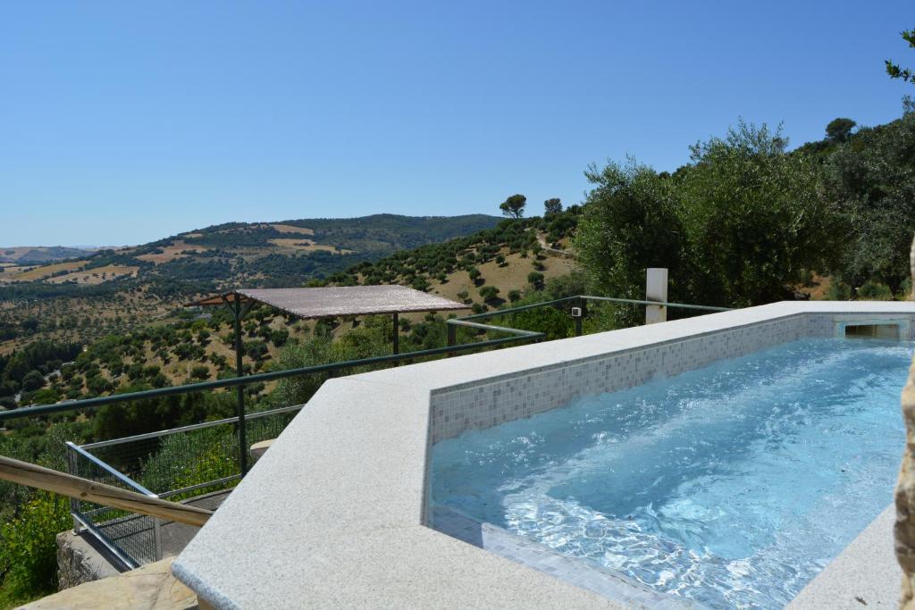 a swimming pool with a view of a mountain at Las Cuevas de El Bosque in El Bosque