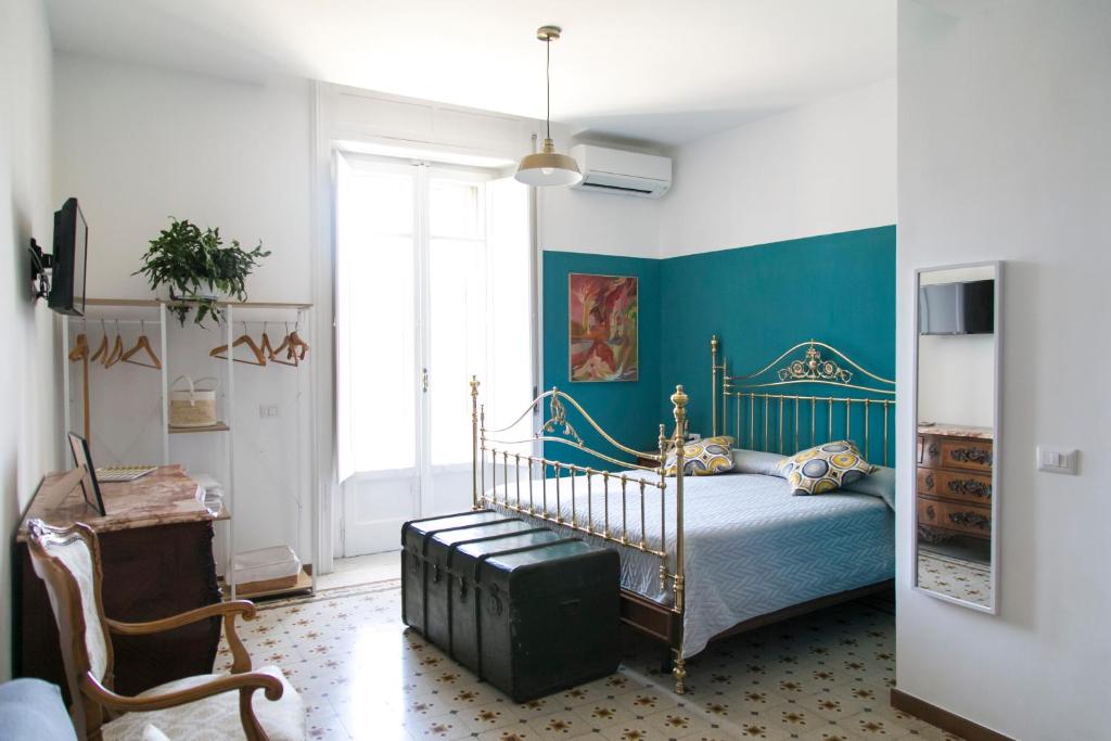- une chambre avec un lit et un mur bleu dans l'établissement A Casa di Nina Guest House, à Naples