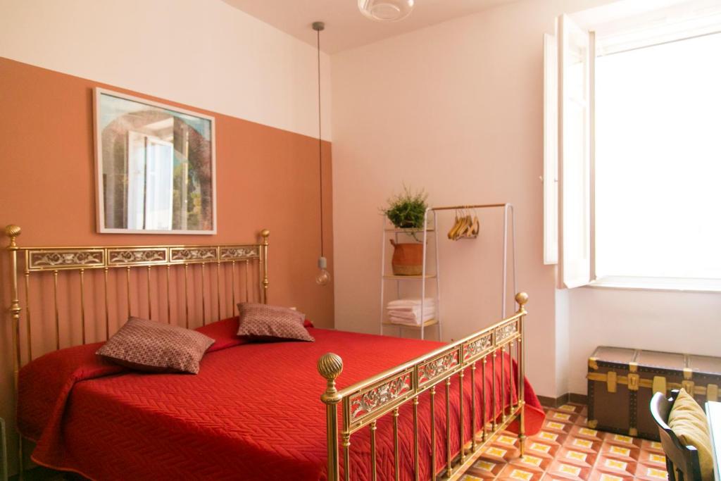 sypialnia z łóżkiem z czerwoną pościelą i oknem w obiekcie A Casa di Nina Guest House w mieście Neapol