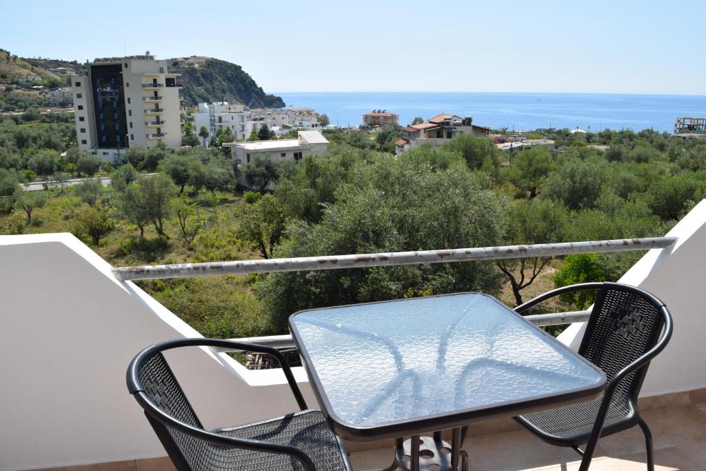 una mesa y sillas en un balcón con vistas al océano en Velco BB Himara en Himare