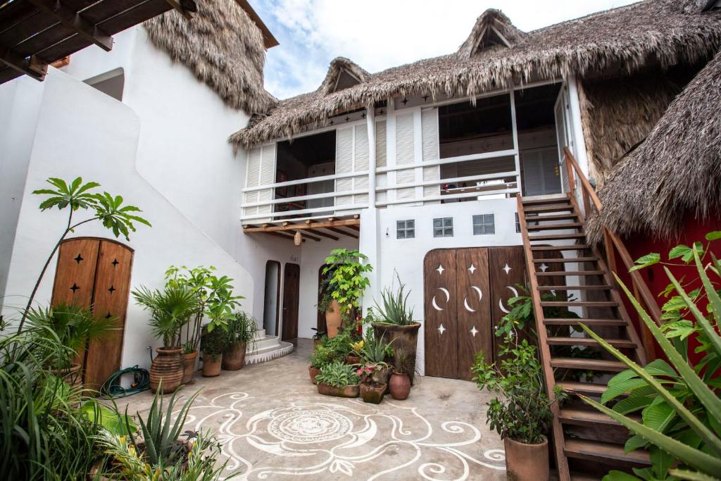 an exterior view of a house with a thatch roof at Casa Love in Sayulita
