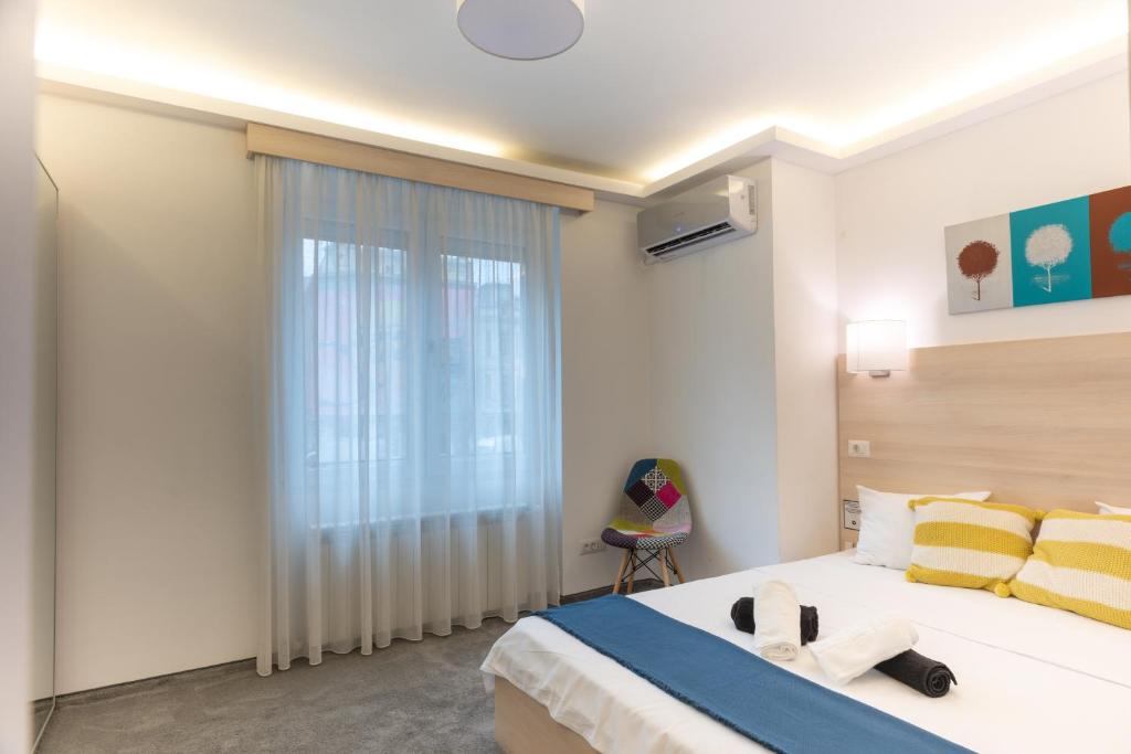 a bedroom with a large bed and a window at MBM Studio Piata Romana Square in Bucharest