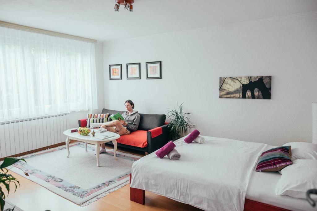Ein Mann auf einer Couch im Wohnzimmer in der Unterkunft Sophies World in Sarajevo