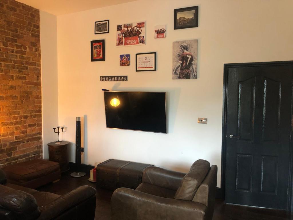 a living room with a couch and a flat screen tv at Just by the Gormly MenAnother Place Near Liverpool 13 Abbortford Road Crosby Liverpool L23 6ux in Crosby