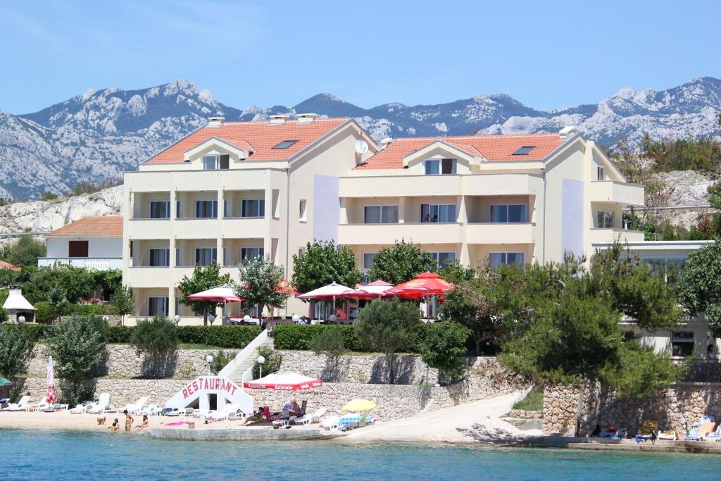 a resort on the water with a beach and buildings at Pension Villa Rosa in Rtina