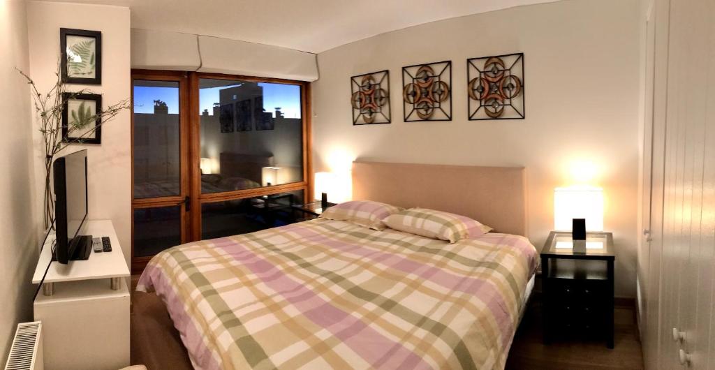 um quarto com uma cama com 2 candeeiros e uma janela em Fantastico Refugio en La Parva em La Parva