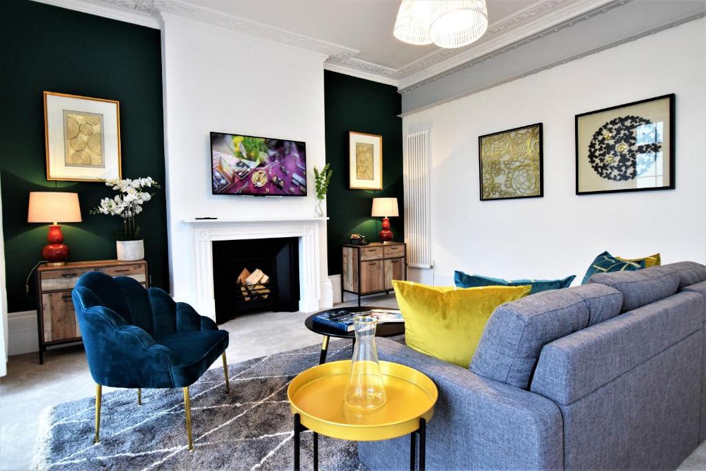 Frederick Place - Your Apartment في بريستول: غرفة معيشة مع أريكة وكراسي ومدفأة