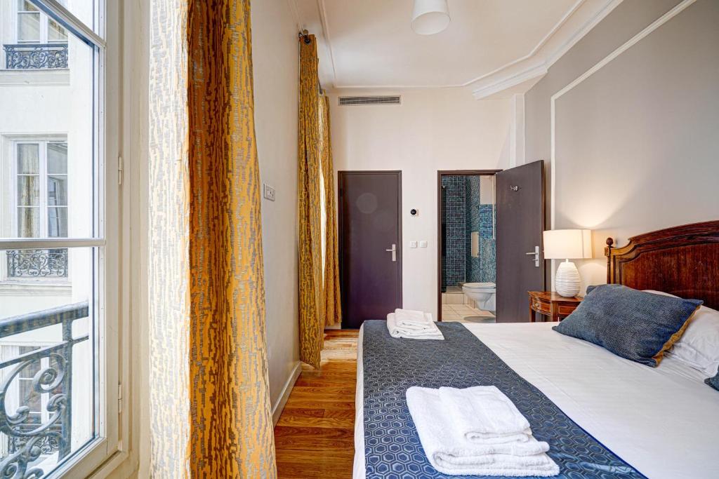 Postel nebo postele na pokoji v ubytování Apartments Du Louvre - Le Marais