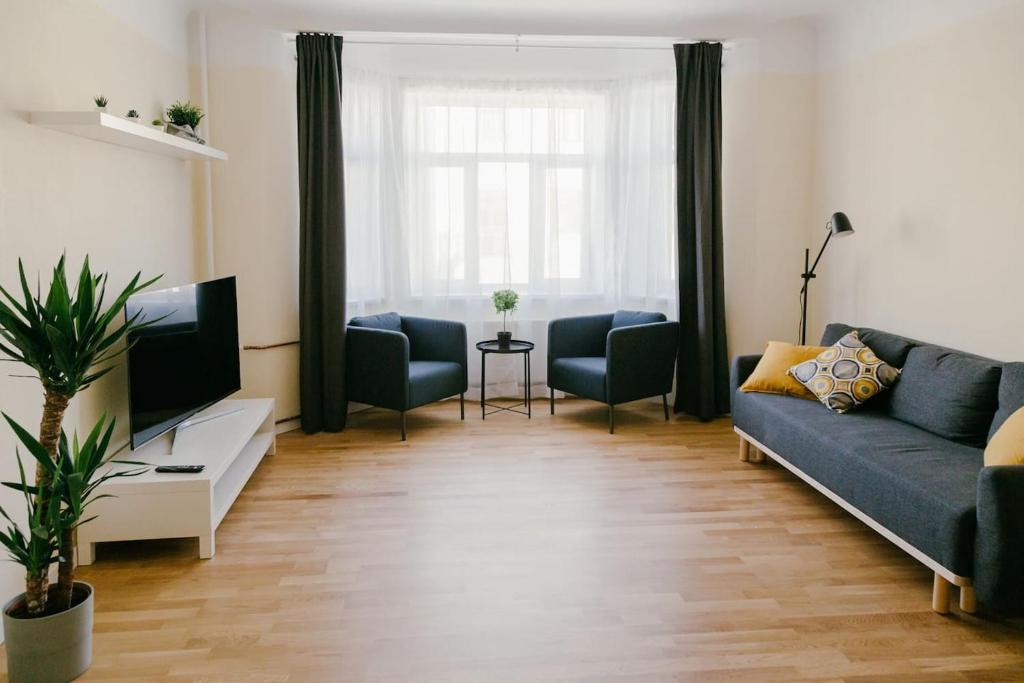 - un salon avec un canapé et une télévision dans l'établissement IZU Home, à Riga