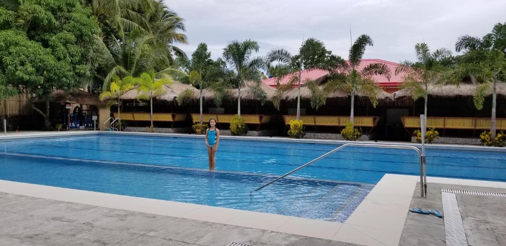 a woman is in a swimming pool at a hotel at Buenavista Family Inn in Tagudin