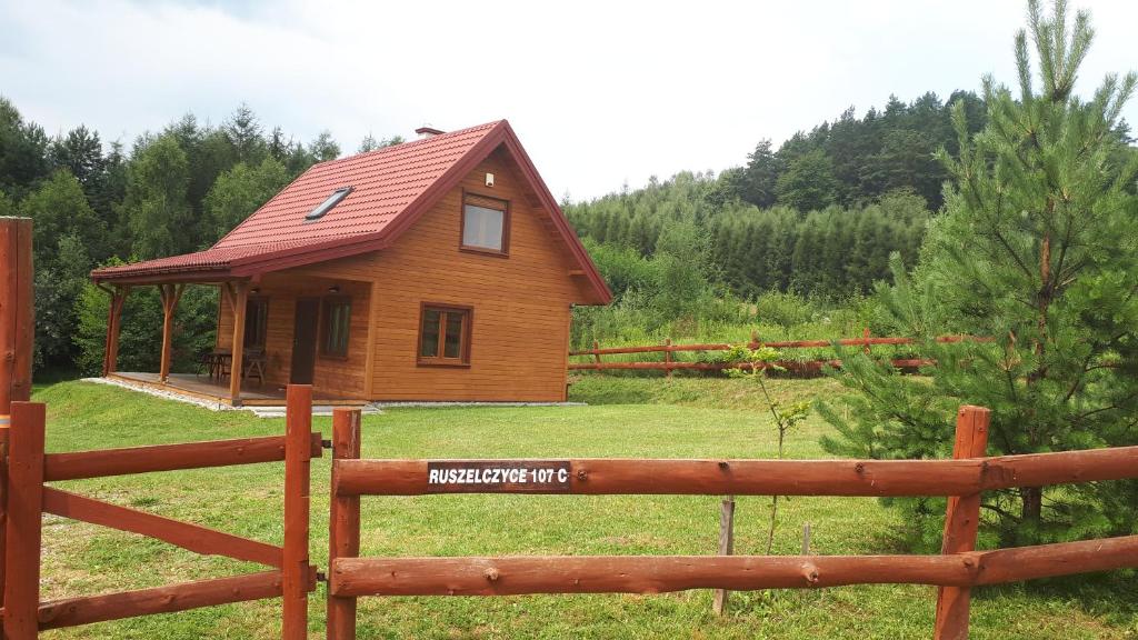 una pequeña casa en un campo detrás de una valla de madera en Dom nad doliną Sanu, en Ruszelczyce