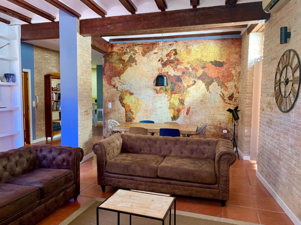 a living room with a couch and a map on the wall at Teixidors de Palomar - PalomarGroup in Valencia