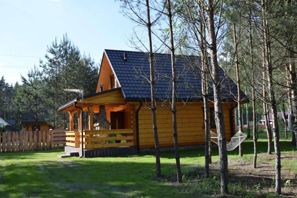 a log cabin with a gambrel roof at Zacisze Leśne- Domek do wynajęcia in Tereszpol Zaorenda