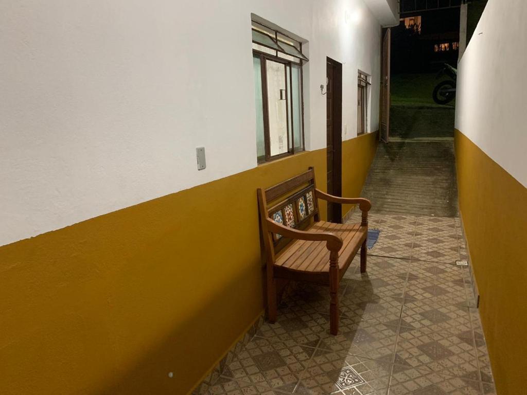 um corredor com uma cadeira de madeira num quarto em casa temporada tiradentes em Tiradentes