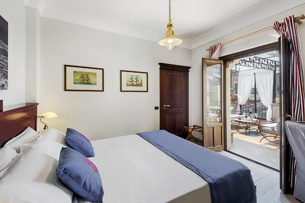 a bedroom with a bed and a sliding glass door at Relais 147 - Luxury b&b in Taormina