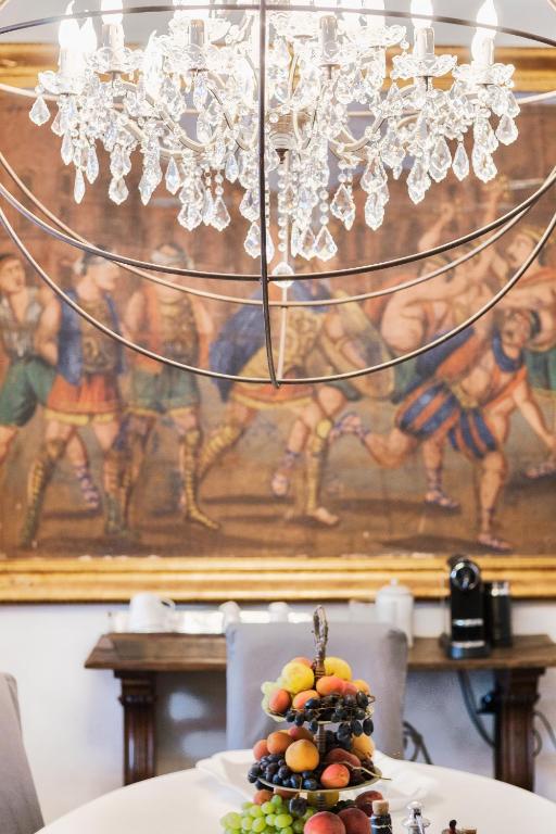 a table topped with a plate of fruit under a chandelier at Relais 147 - Luxury b&b in Taormina