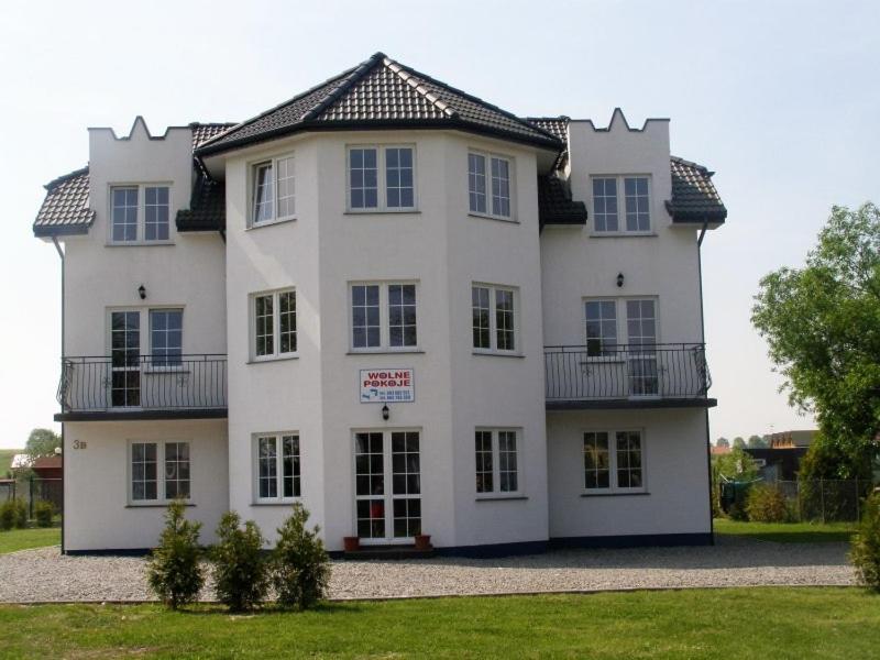 a large white house with a sign on it at Adria in Sarbinowo