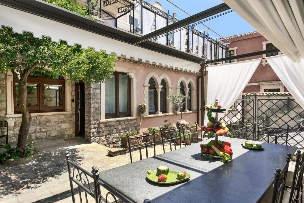 a patio with a table with fruits and vegetables on it at Relais 147 - Luxury b&b in Taormina