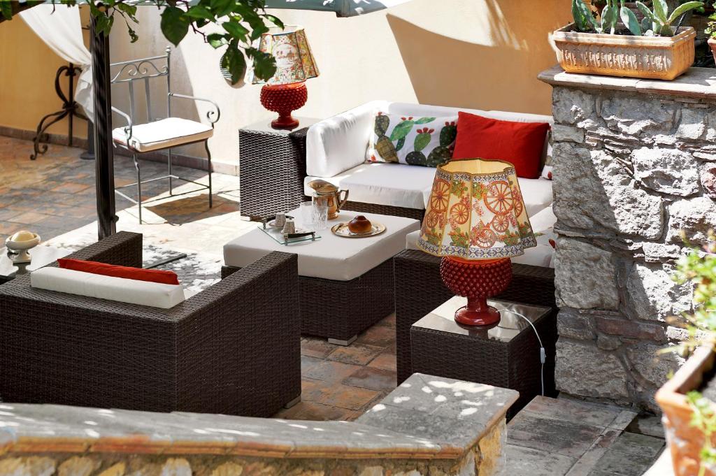 a patio with a couch and a table with a lamp at Relais 147 - Luxury b&b in Taormina