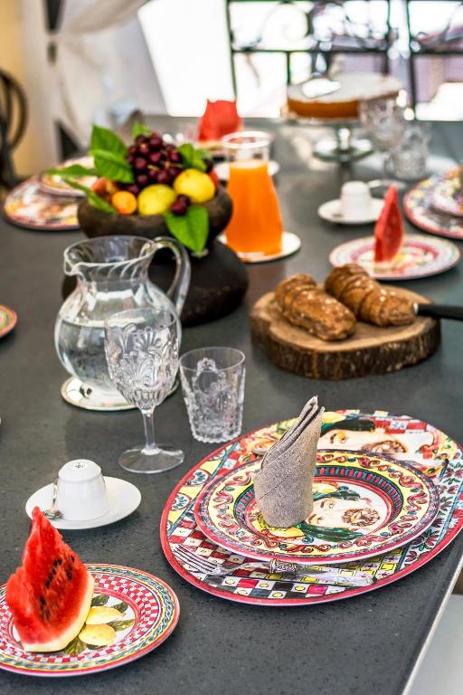 a table with plates of food and fruit on it at Relais 147 - Luxury b&b in Taormina