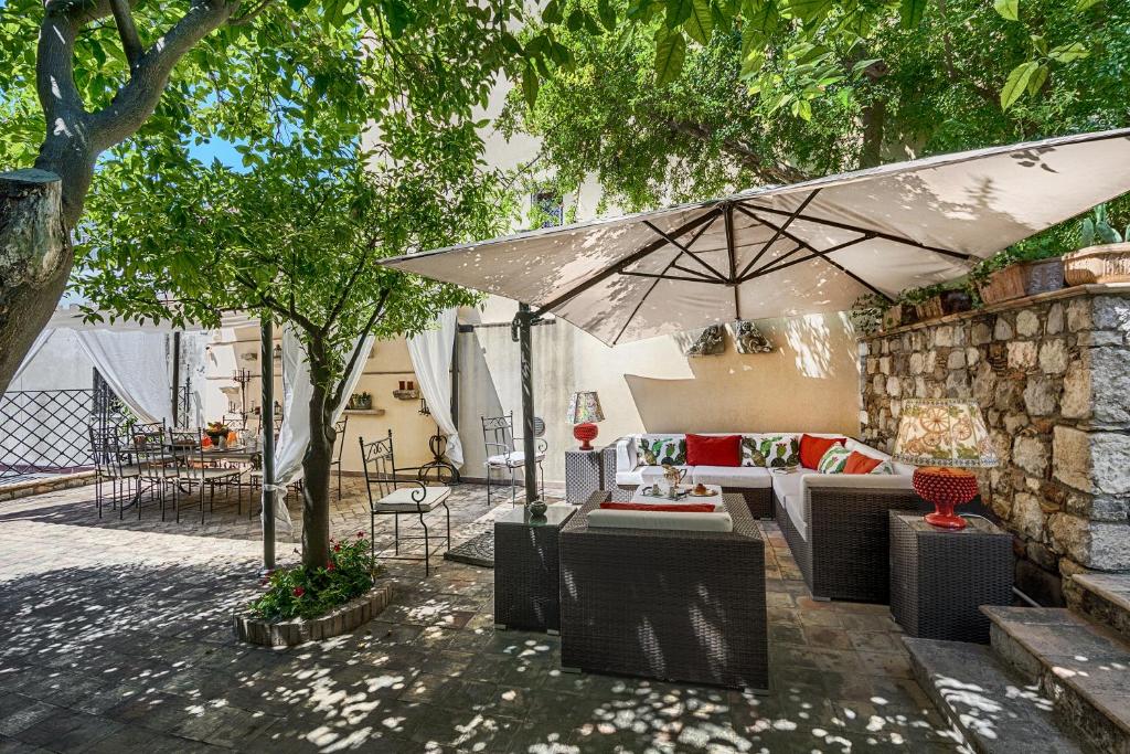 a patio with a couch and an umbrella at Relais 147 - Luxury b&b in Taormina