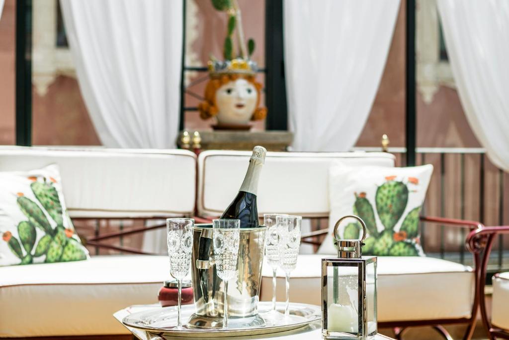 a table with a bottle of champagne and glasses on it at Relais 147 - Luxury b&b in Taormina