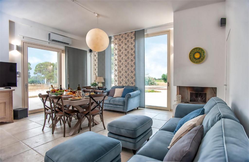 a living room with a blue couch and a table at Le stanze di chiara in Torre Lapillo