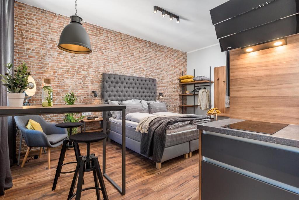a bedroom with a bed and a kitchen with a bar at Porto Marina apartments in Rijeka
