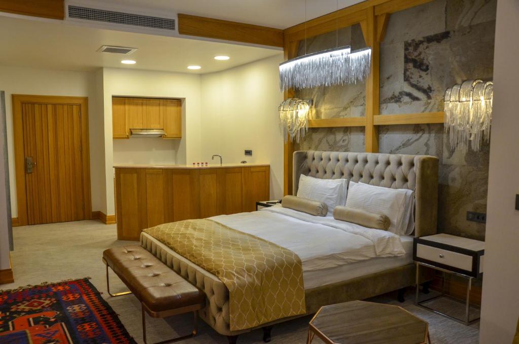 a bedroom with a large bed and a kitchen at Shirvanshah Hotel in Baku
