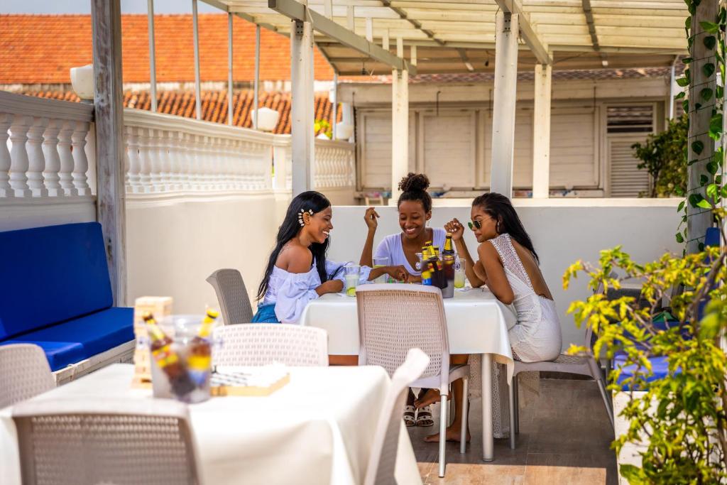 un grupo de personas sentadas en una mesa en un restaurante en Casa Noir Cartagena, en Cartagena de Indias