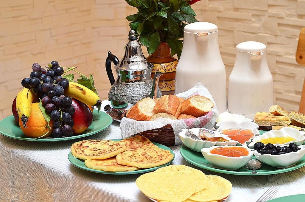 una mesa con tres platos de pan y fruta en Riad Abjaou, en Marrakech