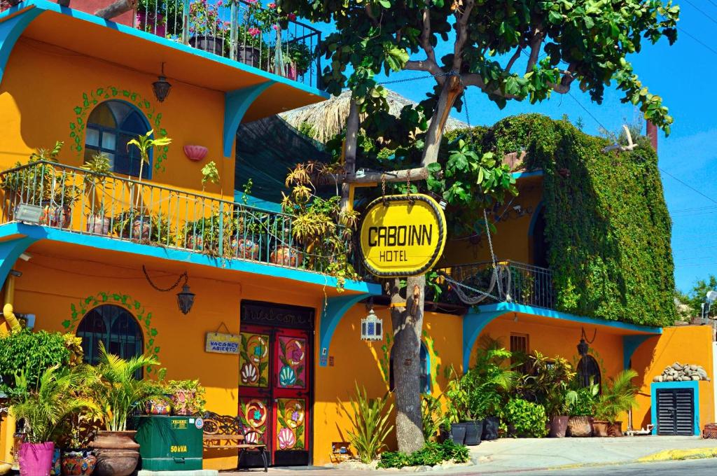 a yellow building with a sign in front of it at Cabo Inn in Cabo San Lucas