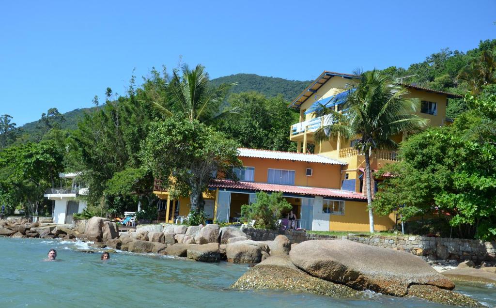 personas nadando en el agua frente a un edificio en Prainha da Nina Apartamentos, en Florianópolis