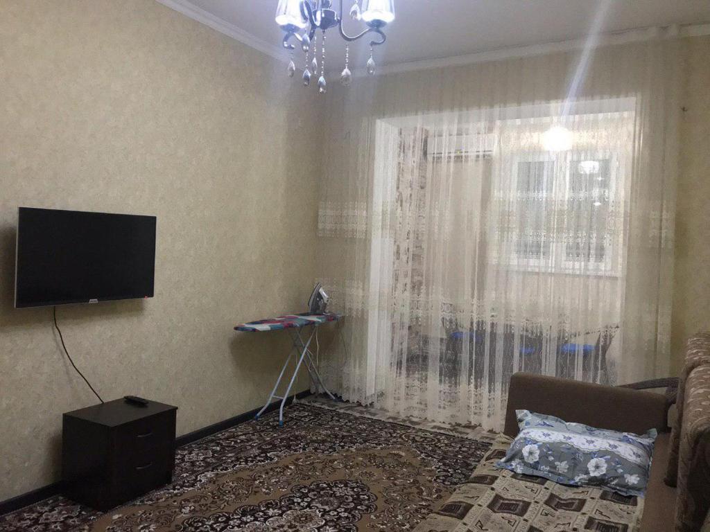 een woonkamer met een tv en een raam bij Apartment Downtown in Tasjkent