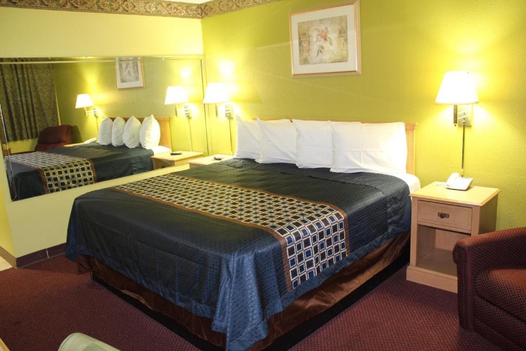 um quarto de hotel com duas camas e uma cadeira em Hutchinson Inn em Hutchinson