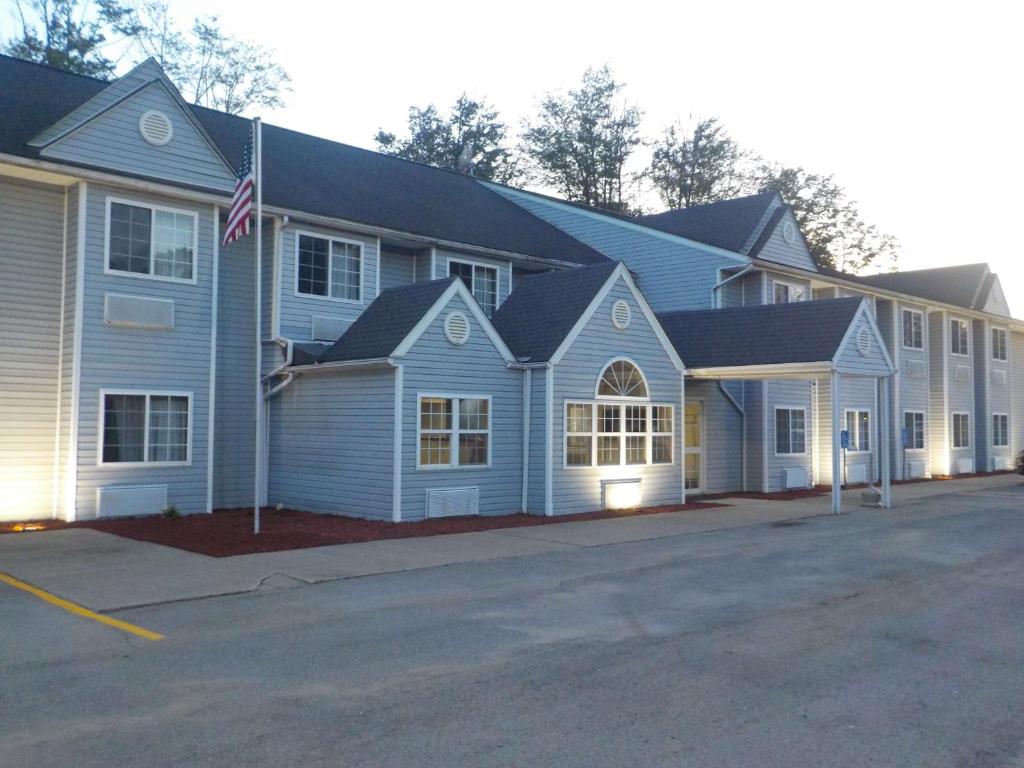 a large blue house with a flag in front of it at MJ INN and SUITES in Marienville