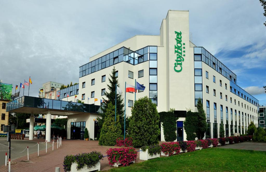 a large white building with a sign on it at City Hotel in Bydgoszcz