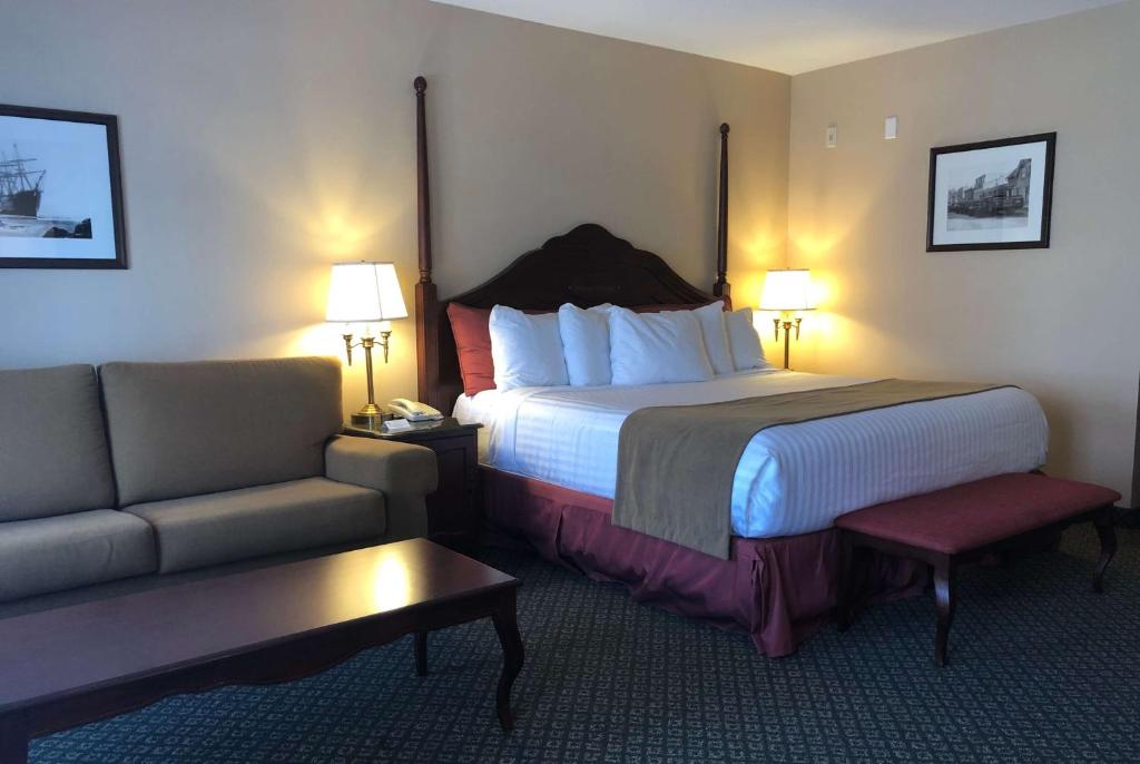 um quarto de hotel com uma cama e um sofá em Chateau Saint John Trademark Collection by Wyndham em Saint John