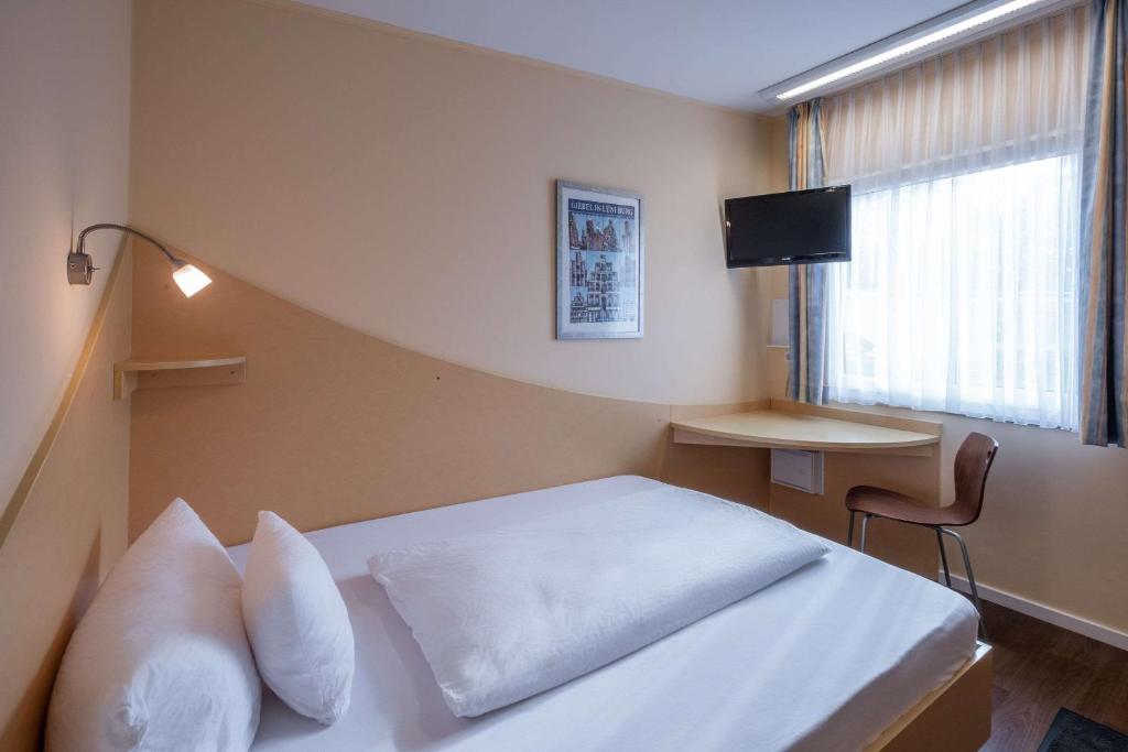 a bedroom with a white bed and a window at Hotel Lüneburg Süd in Melbeck