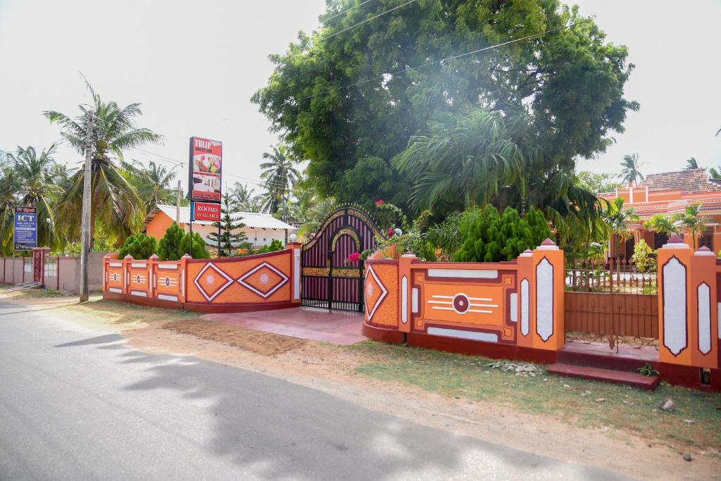 an orange fence with plants on the side of a road at Tulip Guest Inn in Point Pedro