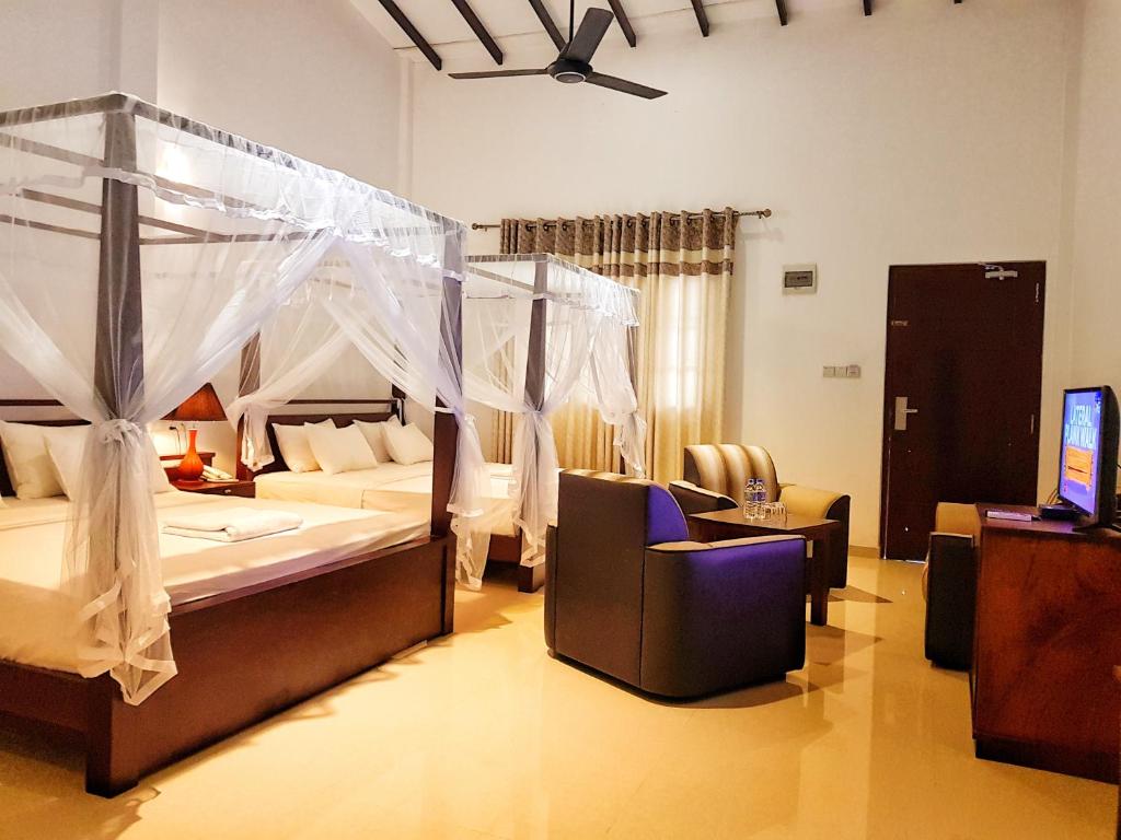 Livinya Holiday Resort في كاتاراغاما: غرفة نوم بسرير كبير مع مظلة